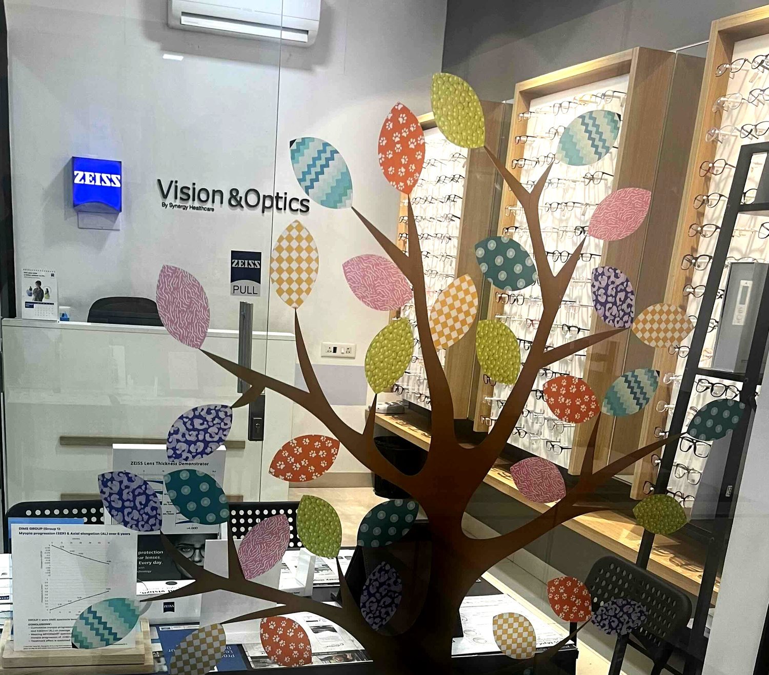 The Tree of Sight artwork painted across the storefront glass at Vision & Optics, Ghodbunder Road, Thane
